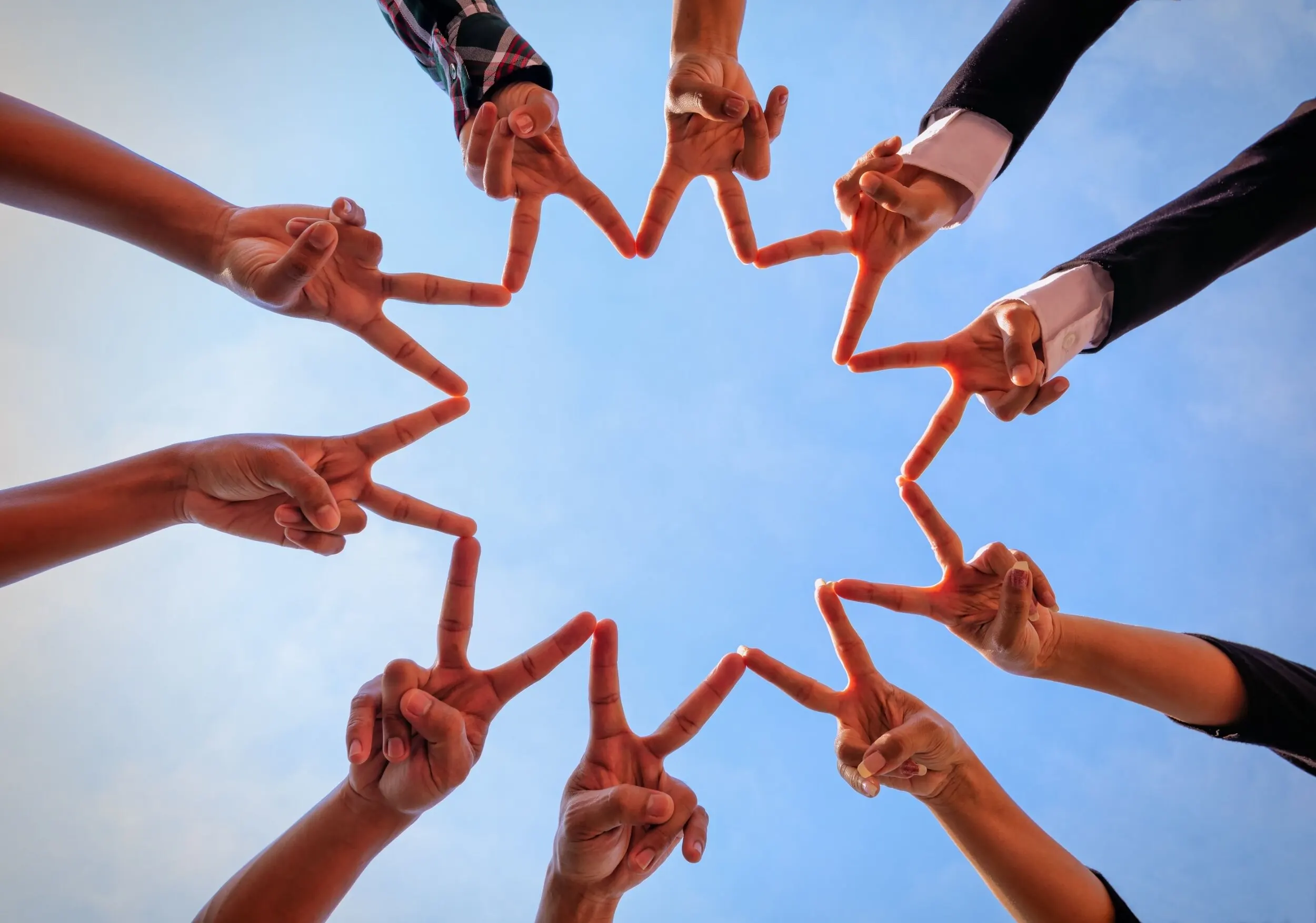 Team members have made a star with their fingers.