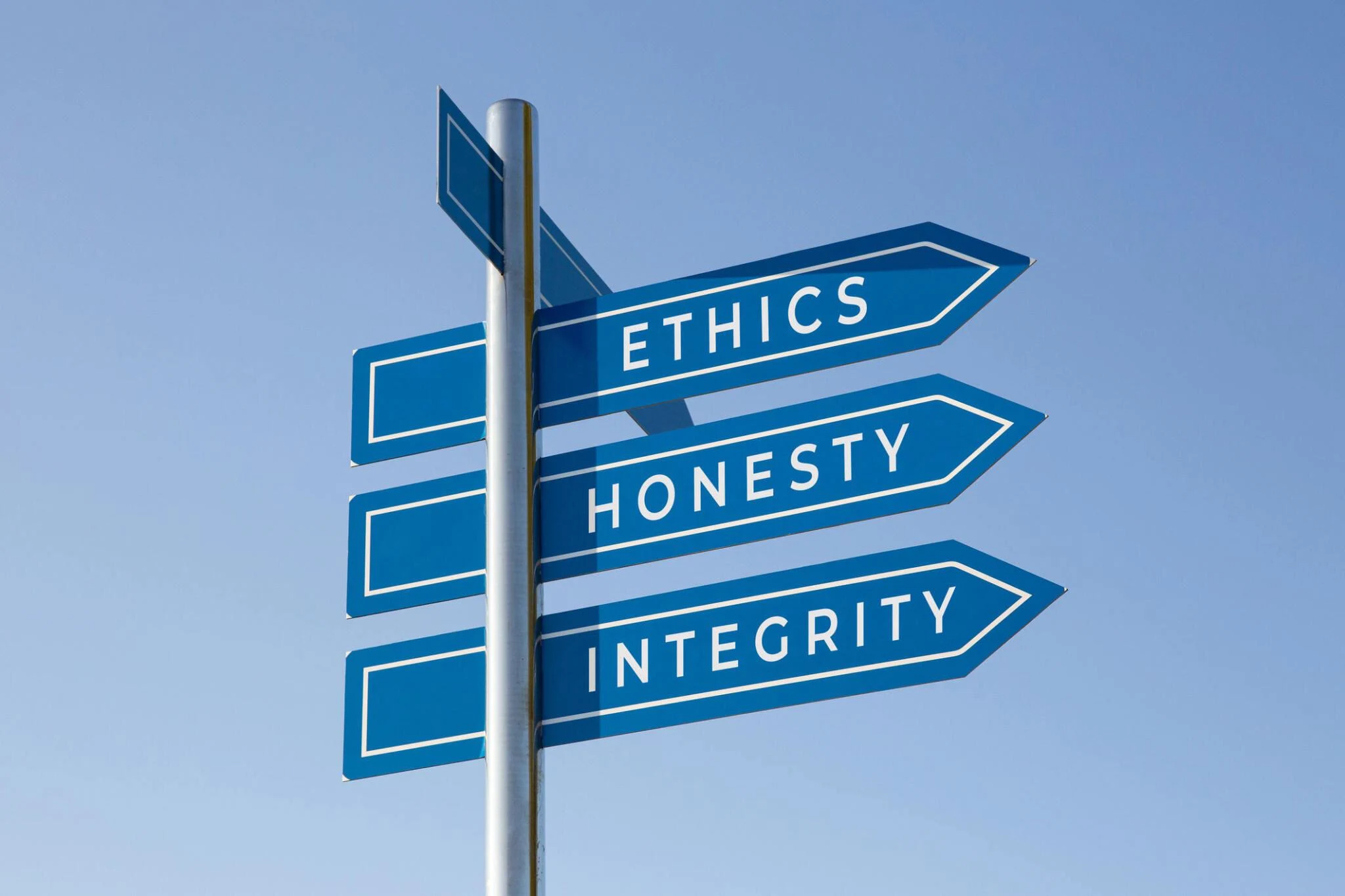 Ethics honesty integrity words on signpost isolated on sky background.